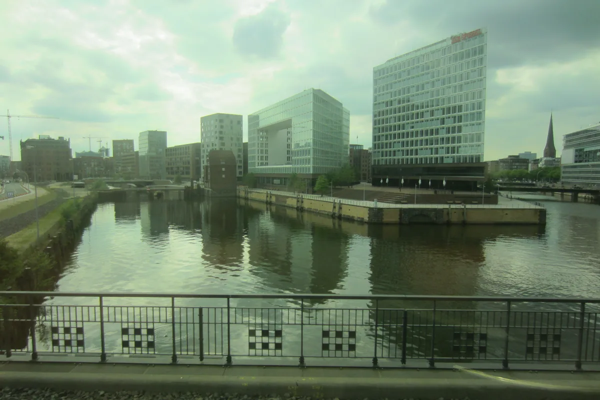 View from a train towards water and modern buildings in Hamburg