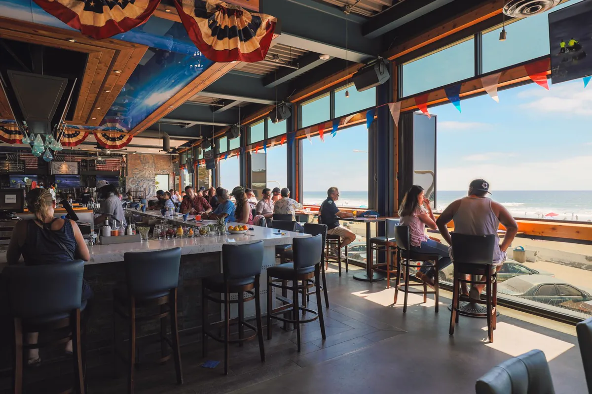Guests inside Waterbar looking out towards the beach and Pacific Ocean in Pacific Beach