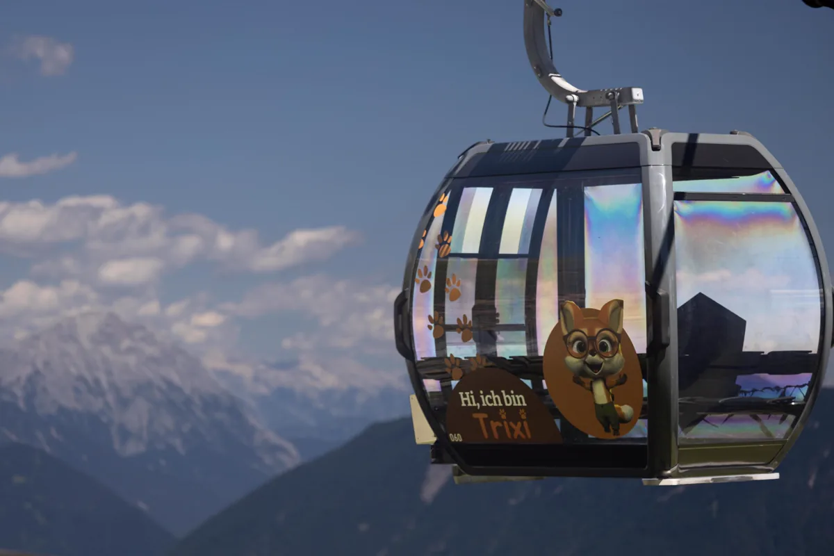Gondola decorated with the character Trixi against the mountain scenery of Hoch-Imst