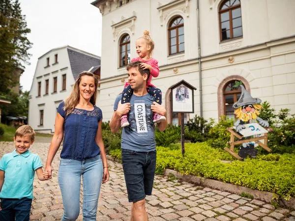 A family walking in Eibenstock in the Ore Mountains in front of a historic building